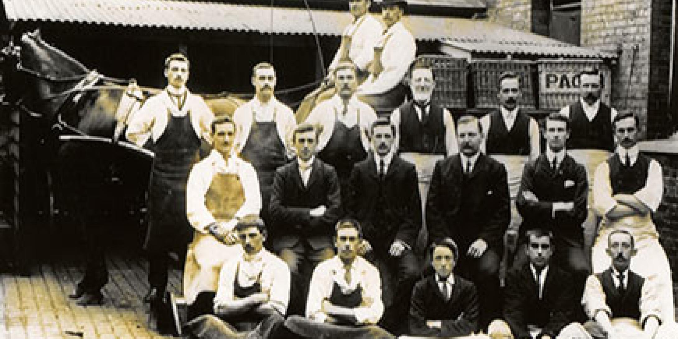 Black and white photo of the first Page & Sons team in front of a horse drawn delivery cart